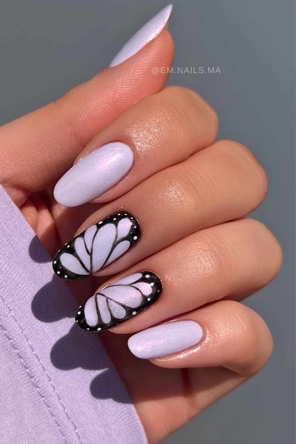 Shimmery purple nails with black butterfly art