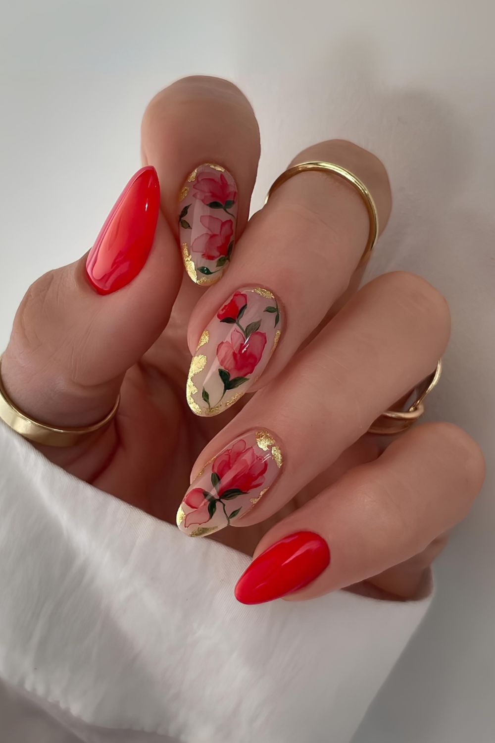 Bright red nails with florals and gold foil accents