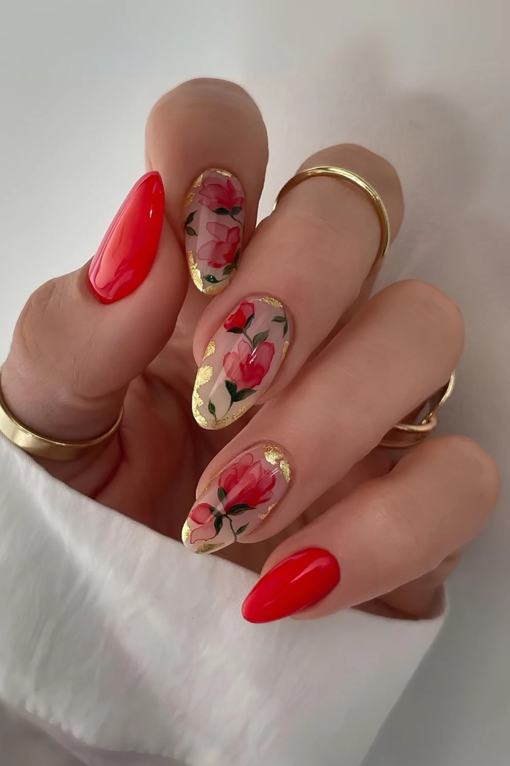 Bright red nails with florals and gold foil accents