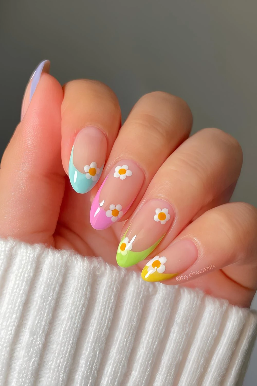 Colorful French tip nails with daisy accents
