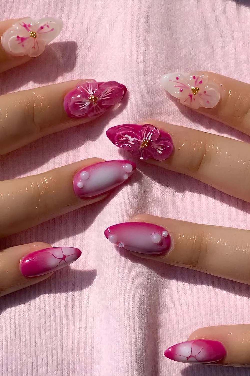 Hot pink nails with textured flowers and pearls