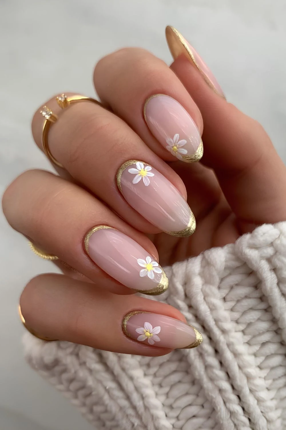 Milky pink nails with gold chrome and white floral accents