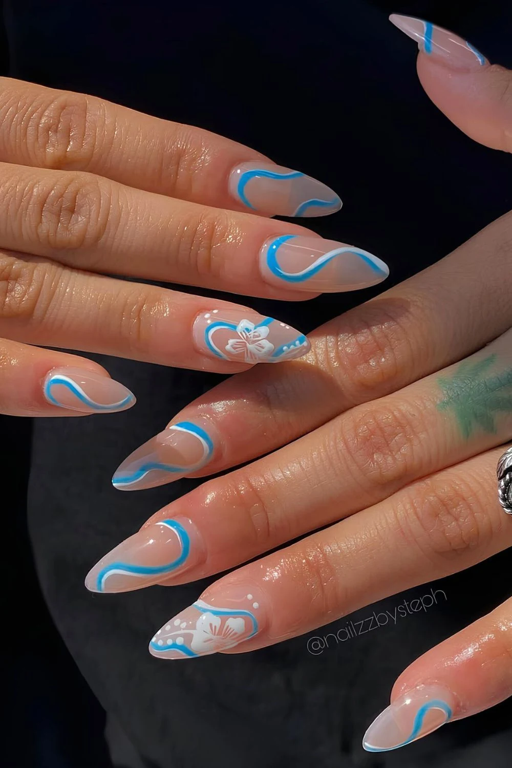 Milky see-through nails with blue and white swirls and hibiscus flowers