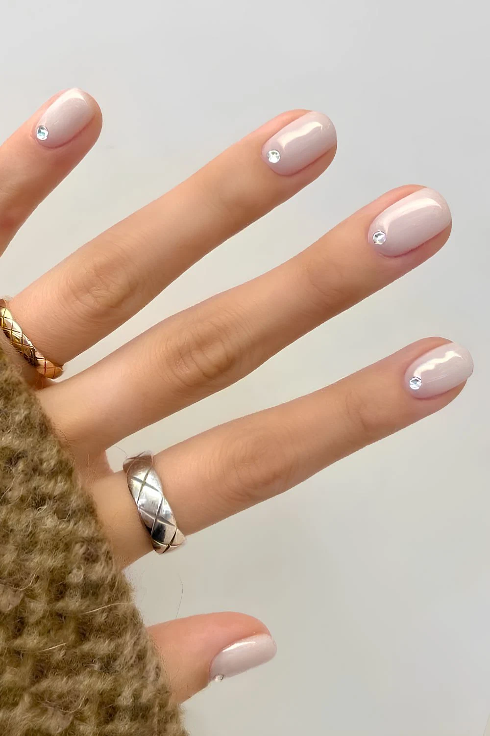 Milky white mani with cuticle rhinestones