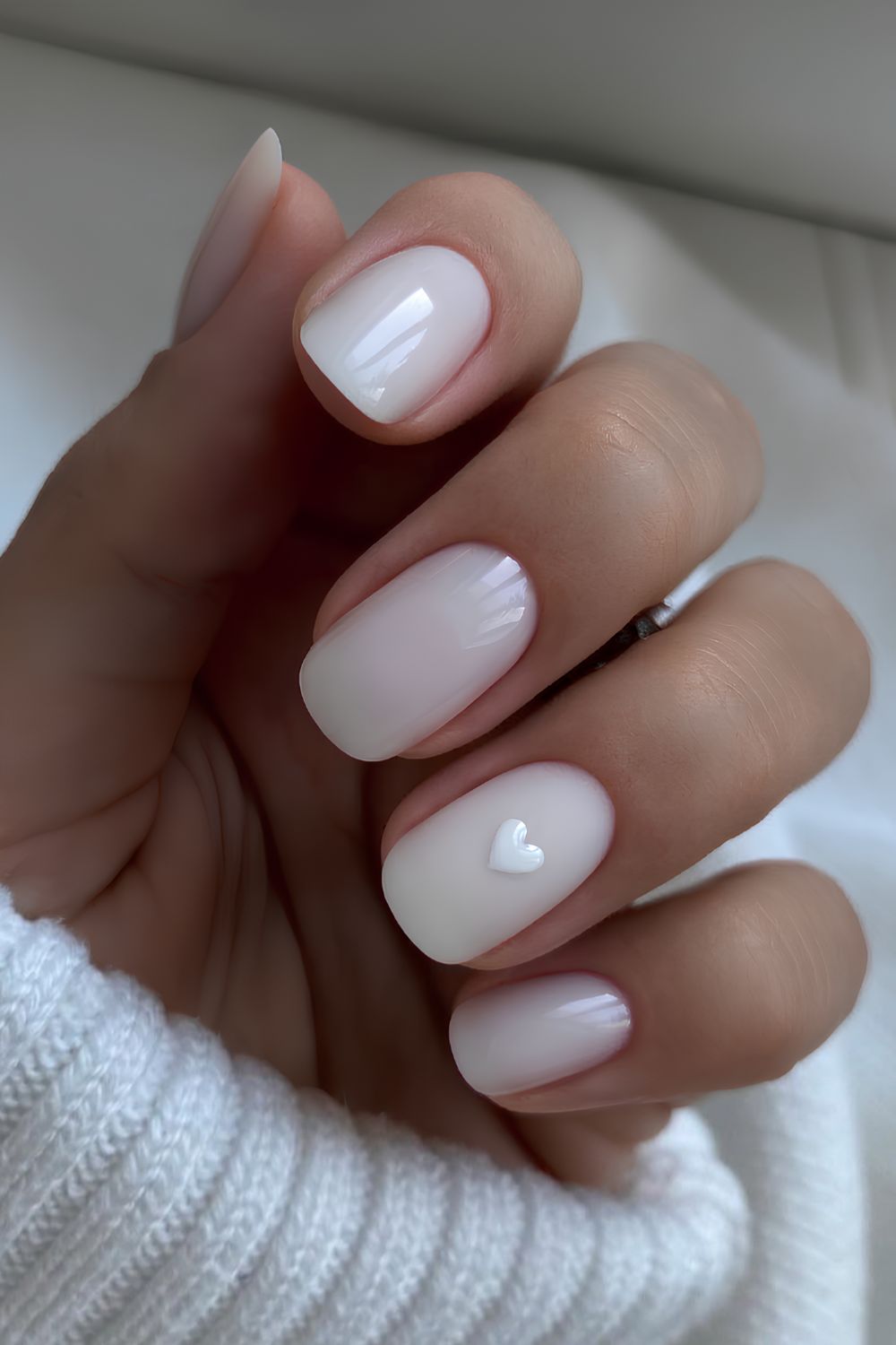 Milky white manicure with minimalist heart art