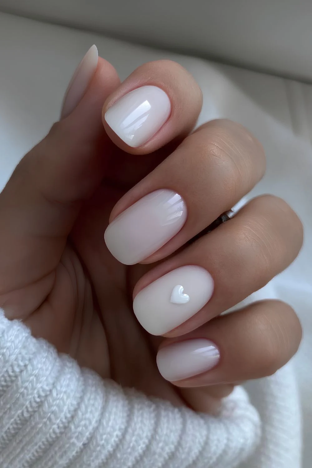 Milky white manicure with minimalist heart art