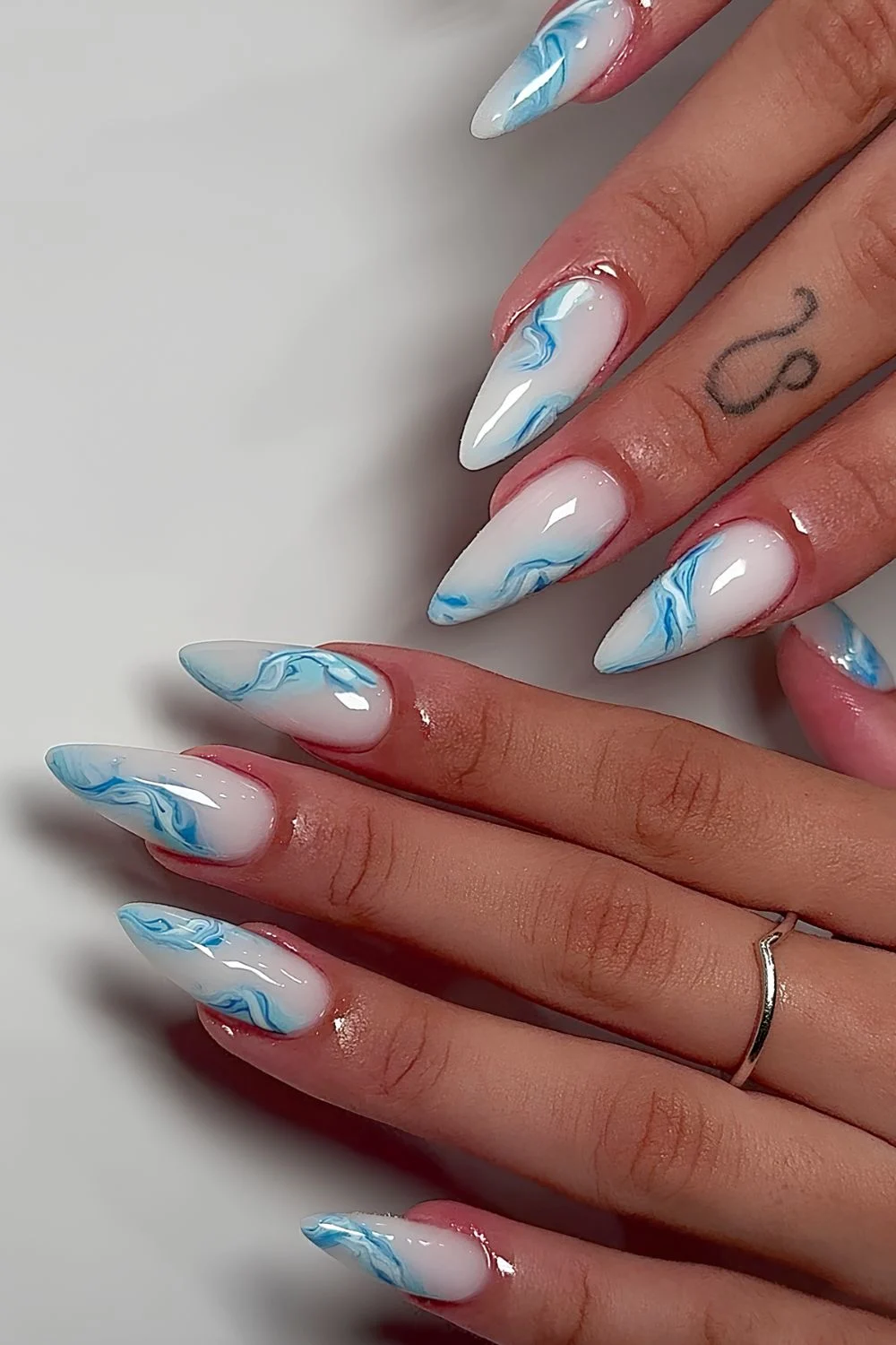 Milky white nails with blue and white marble swirls