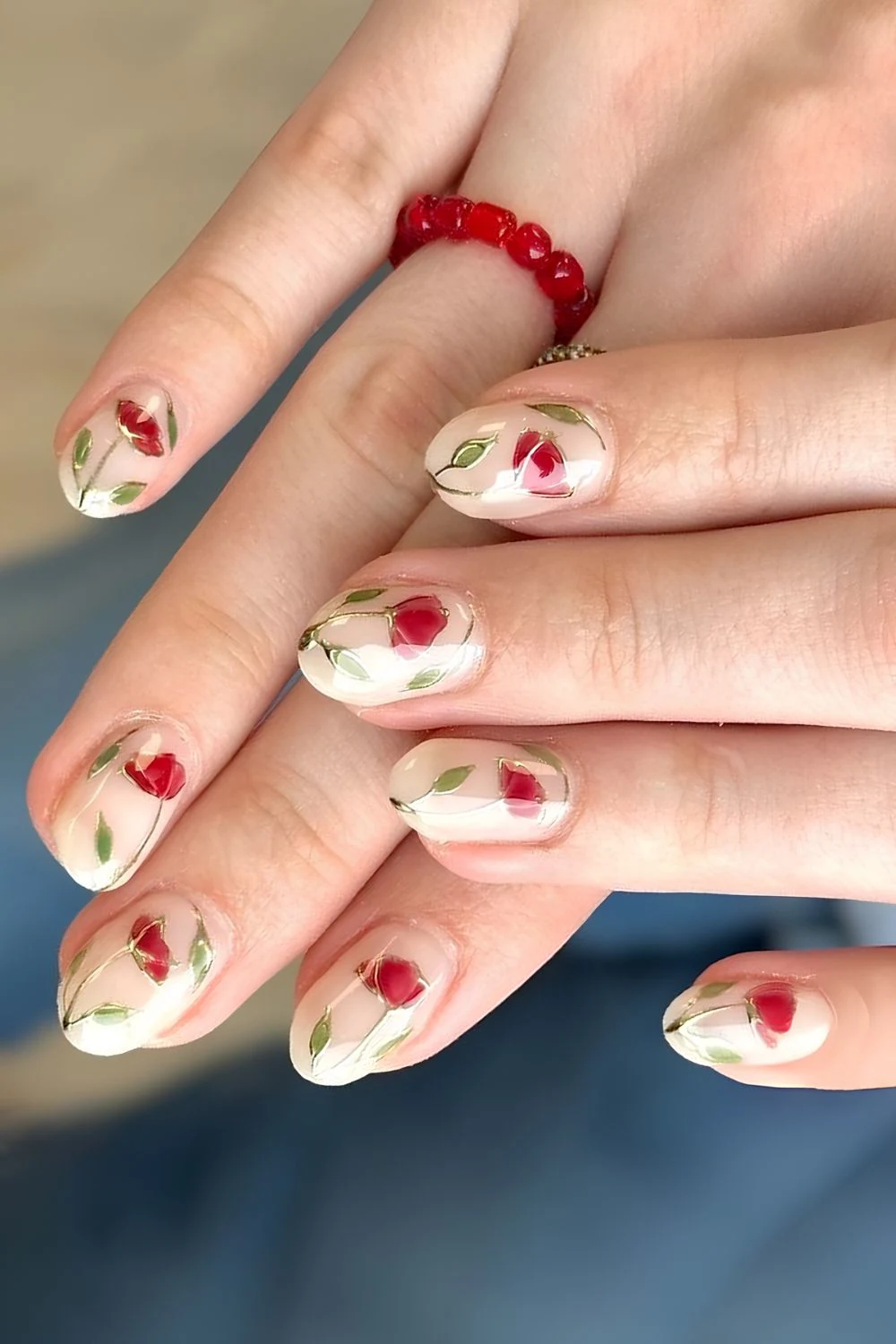 Milky white nails with red carnations and gold accents