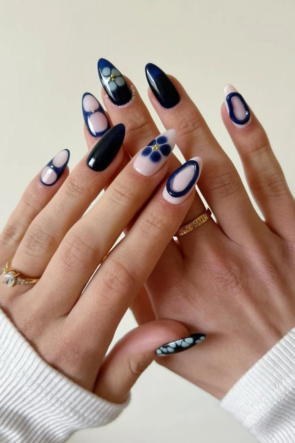 Navy blue and milky pink nails with rings and blooming flowers