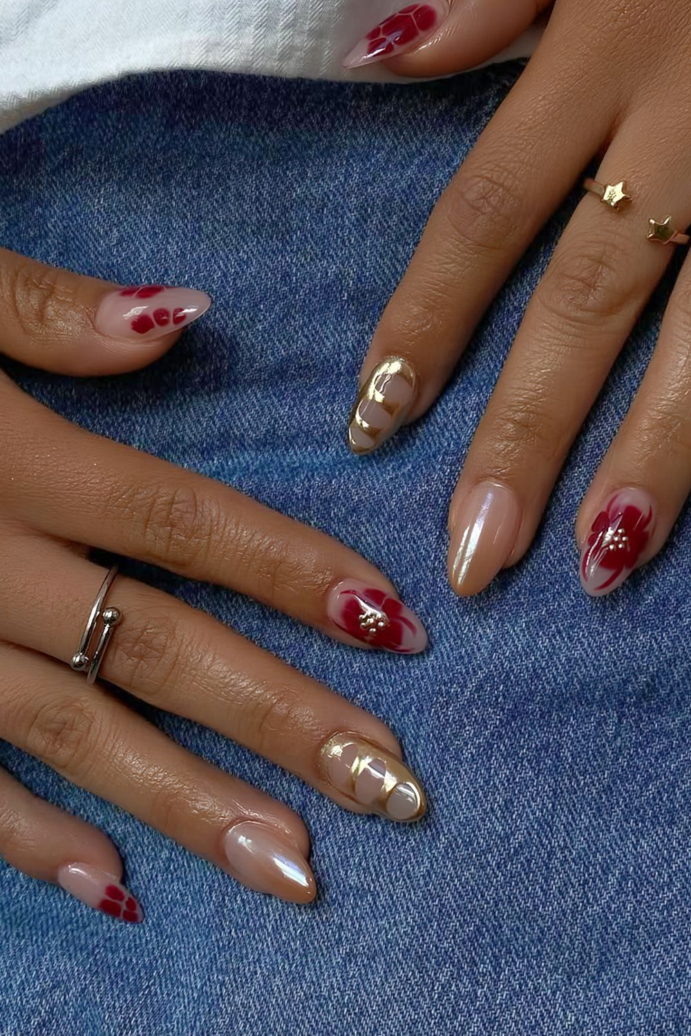 Neutral nails with dark red blooming flowers and gold chrome accents