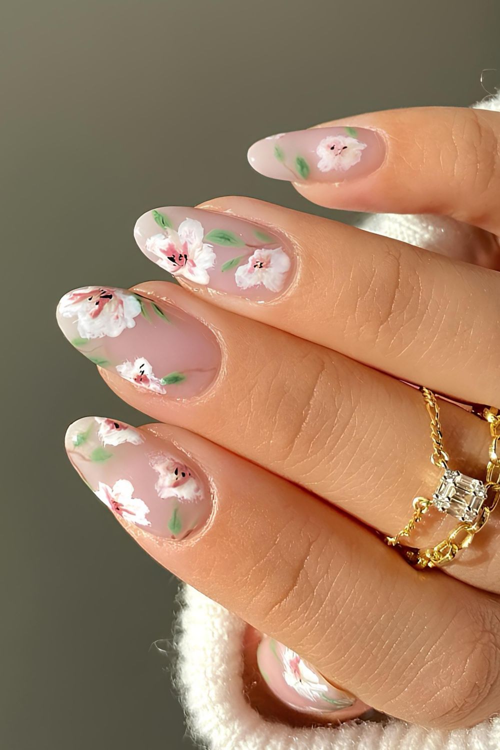 Neutral nails with white handpainted florals and green leaf accents
