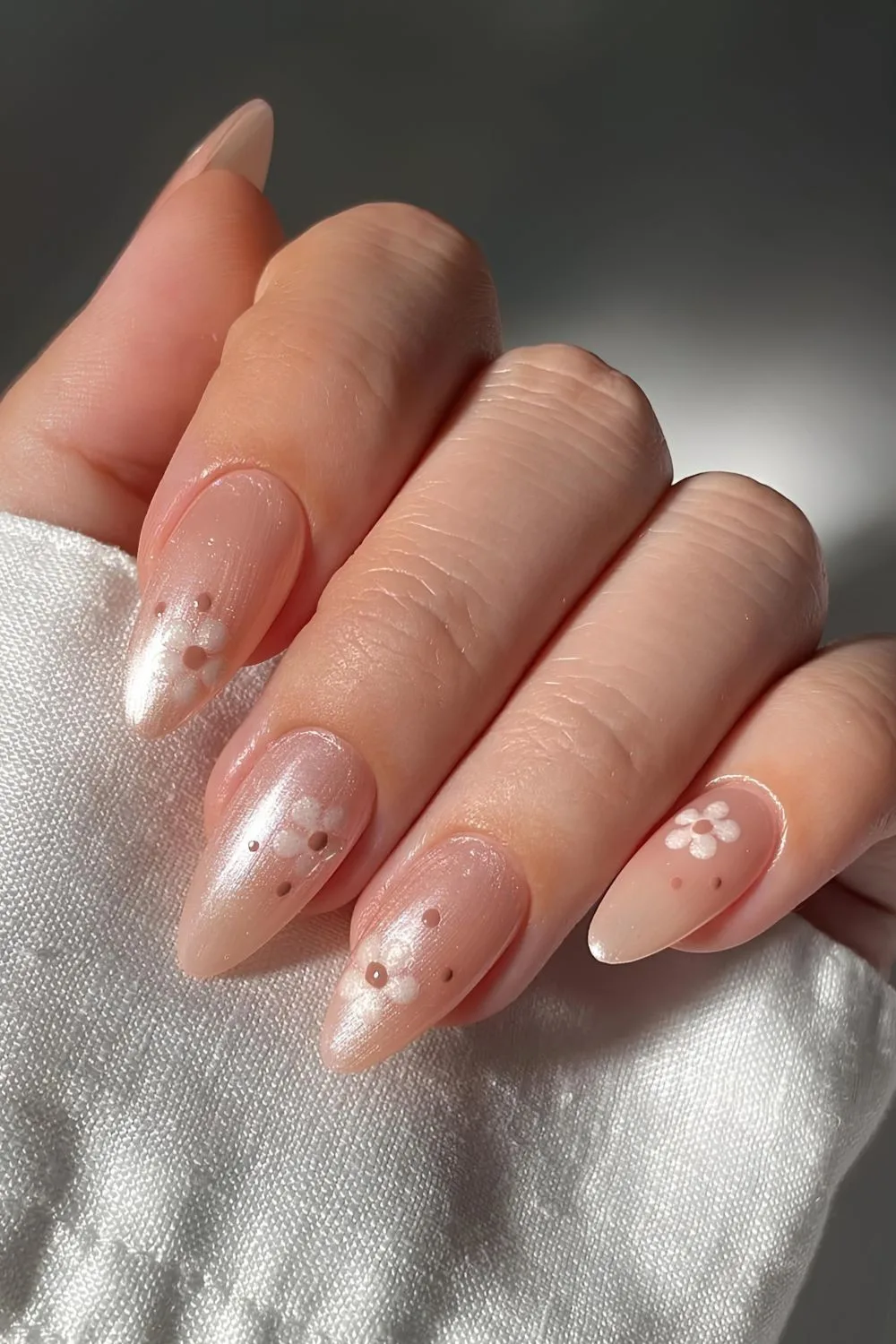 Pearly neutral nails with florals in white and brown dots