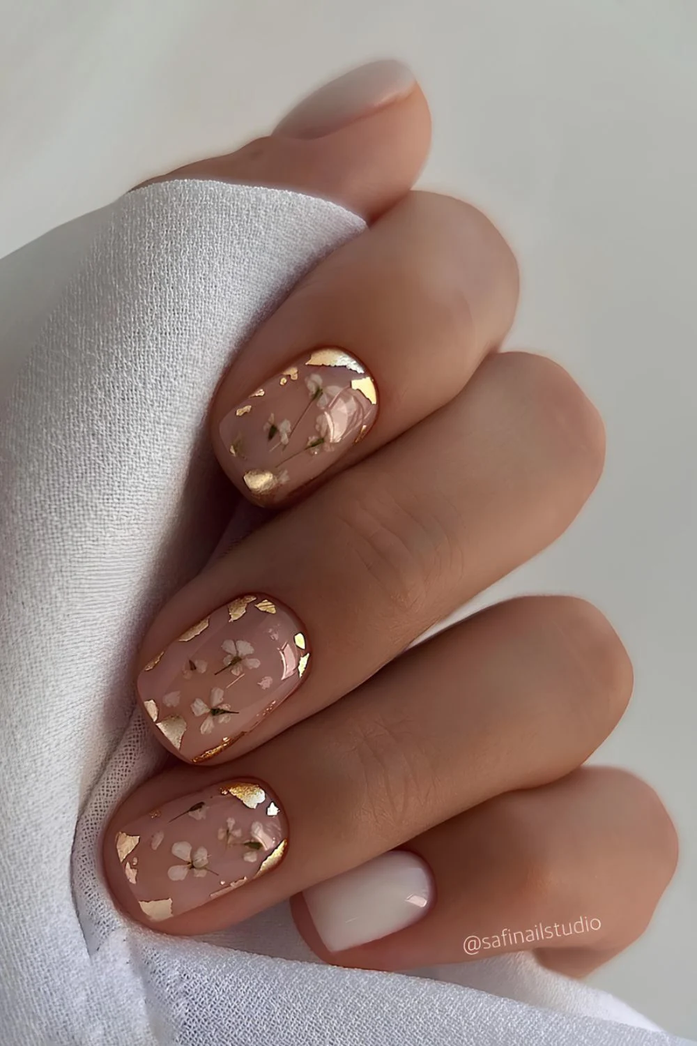 Short milky white and transparent nails with dainty flowers and gold foil