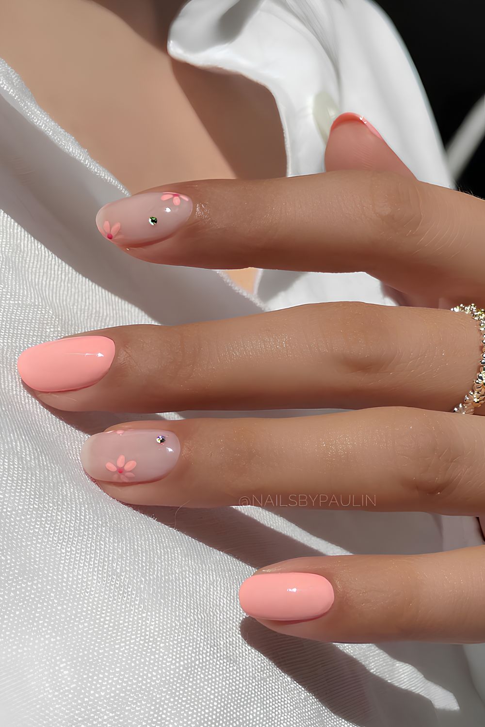 Short peach and sheer milky white nails with flowers and gems
