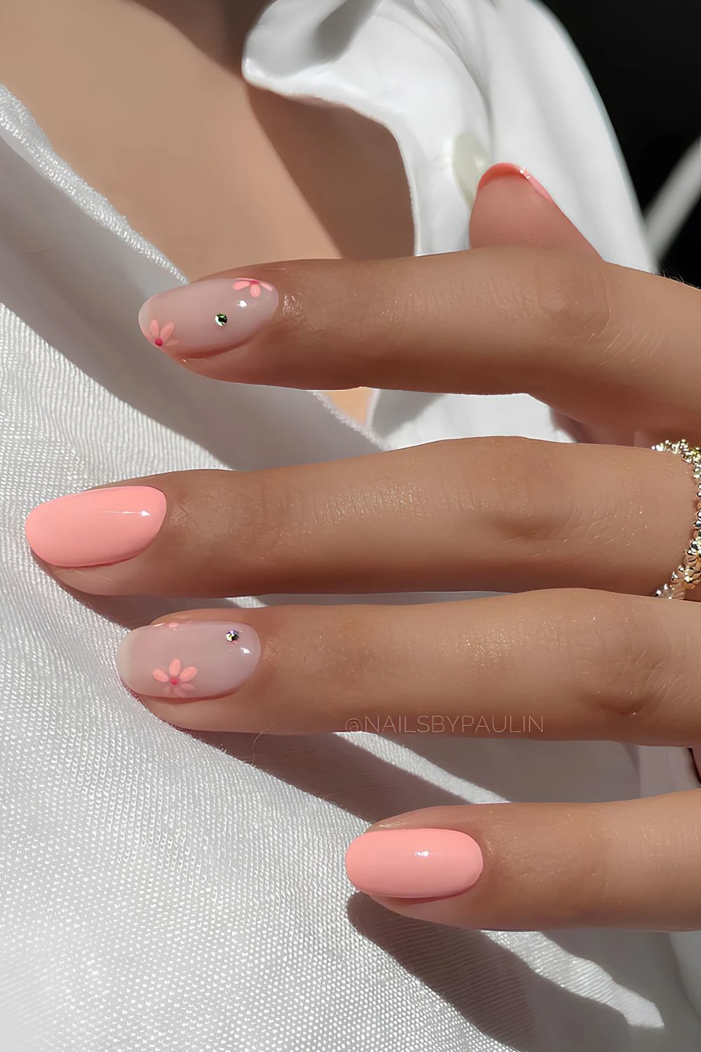 Short peach and sheer milky white nails with flowers and gems