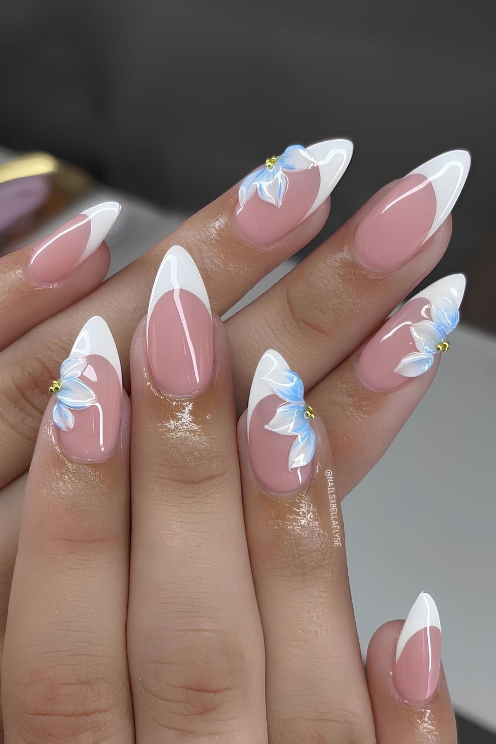 White French nails with sculpted blue flowers