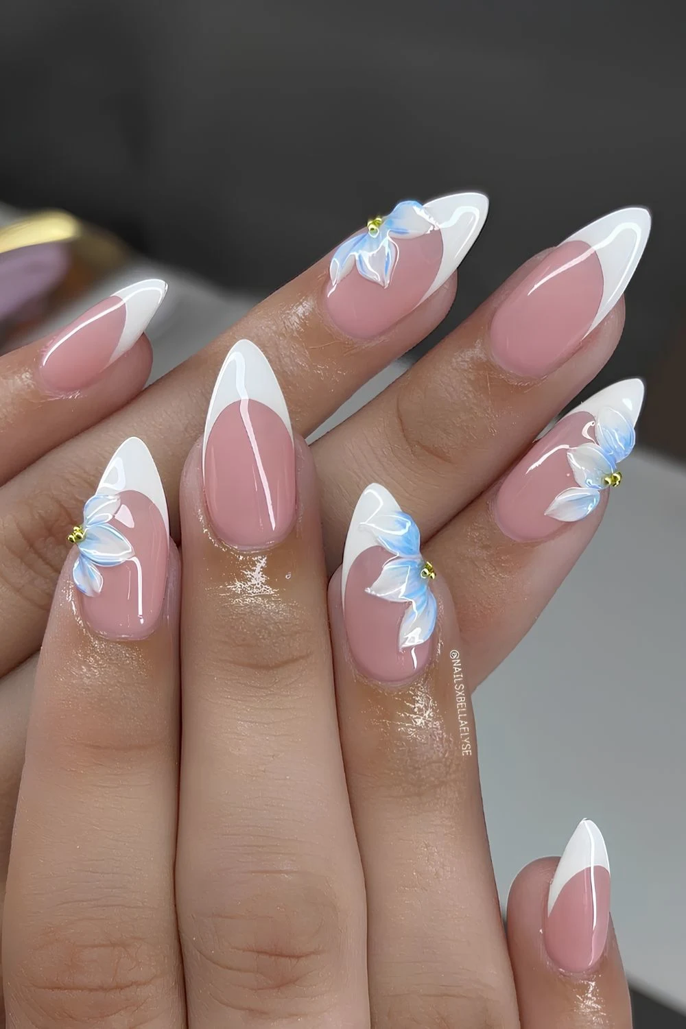 White French nails with sculpted blue flowers
