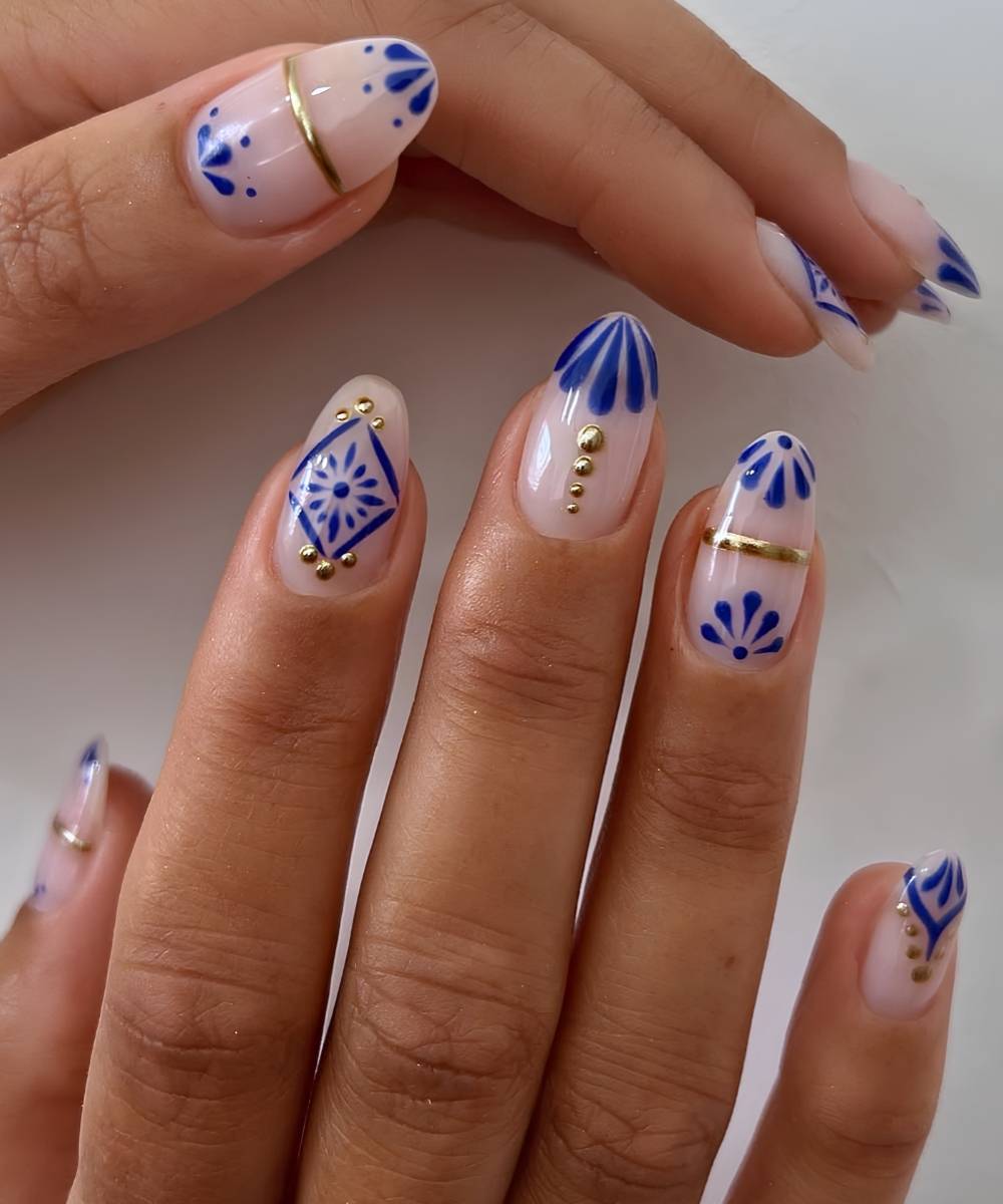 White nails with blue tile florals and gold details