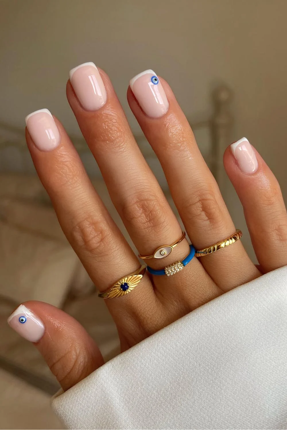 White on white micro French tips with evil eye details