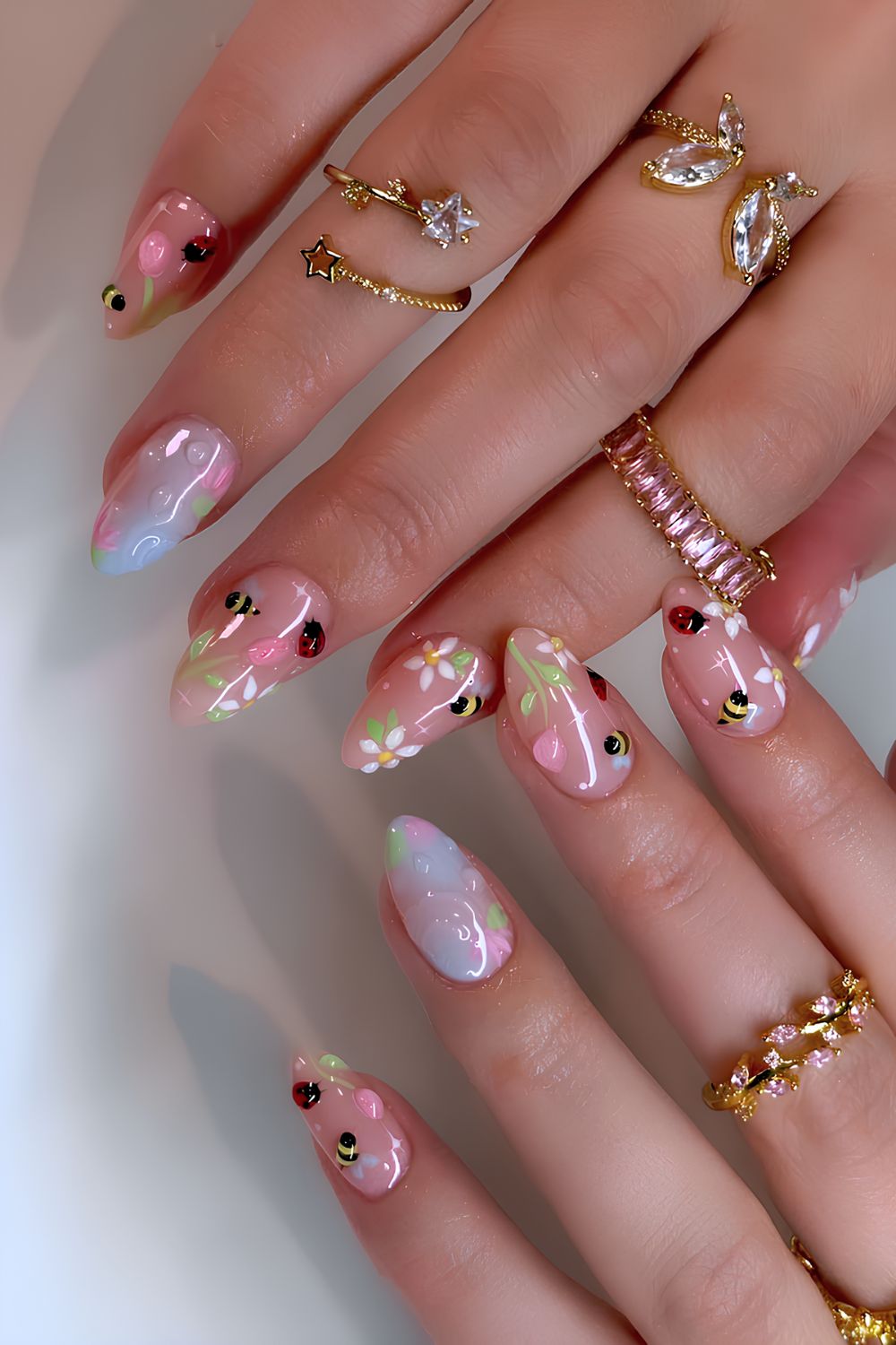 Floral nails with bee and ladybug nail art