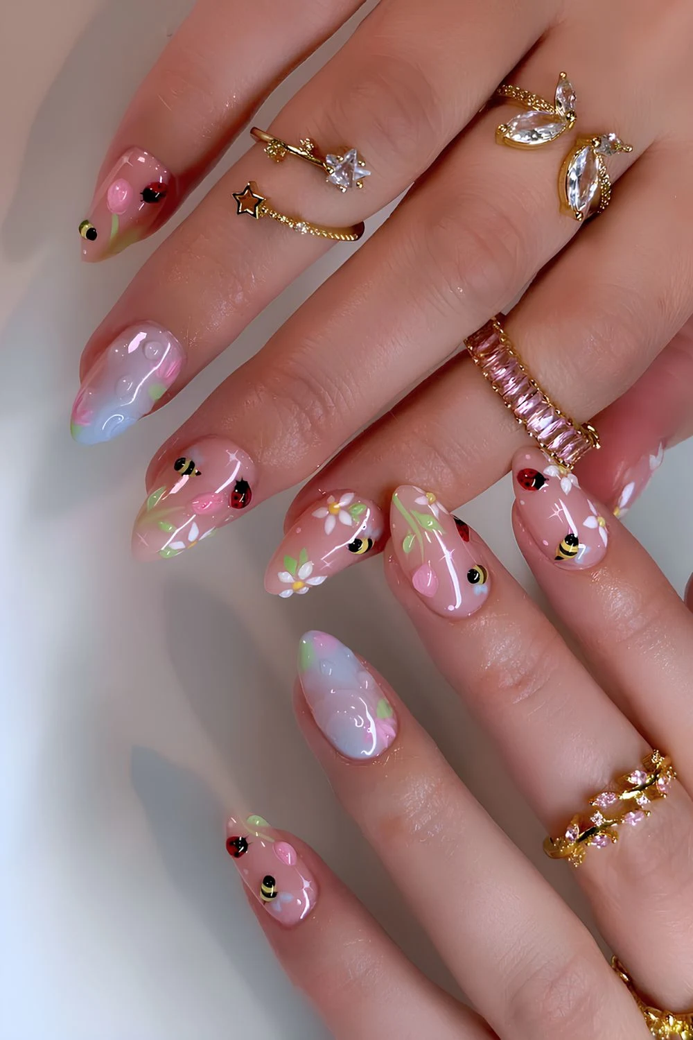 Floral nails with bee and ladybug nail art
