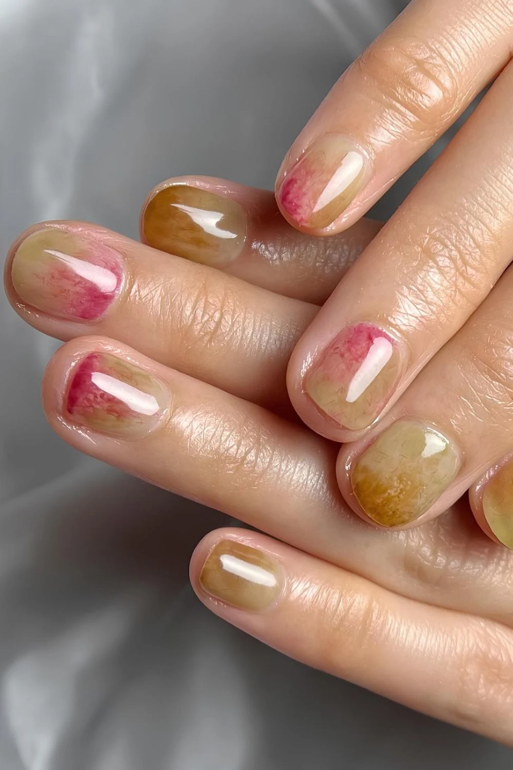 Glossy short nails with green, brown, and red tones inspired by fig and kiwi skin