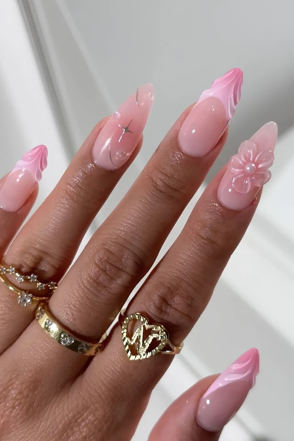 Liht pink gel nails with textured tips and sculpted flower accents