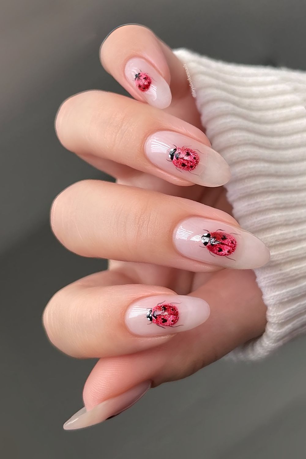 Milky pink base with cat eye ladybug nail art