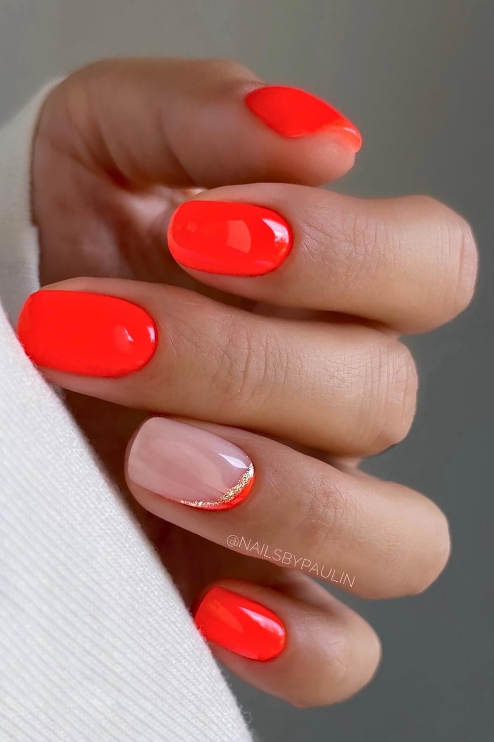 Neon orange nails with glitter detail