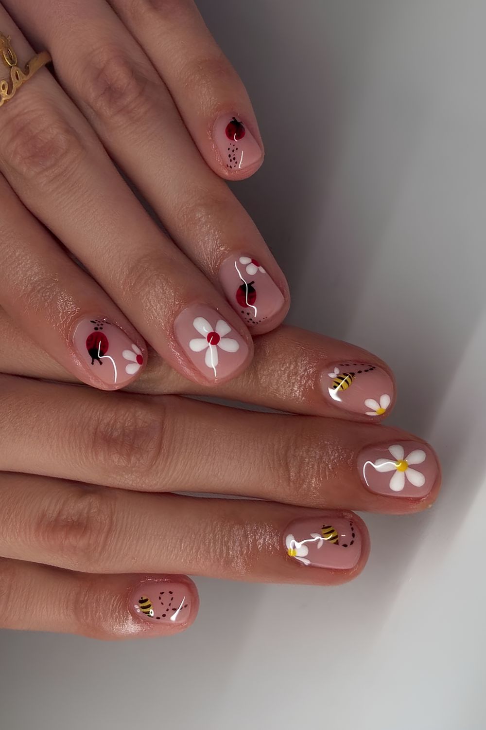 Neutral daisy nails with ladybug and bee accents