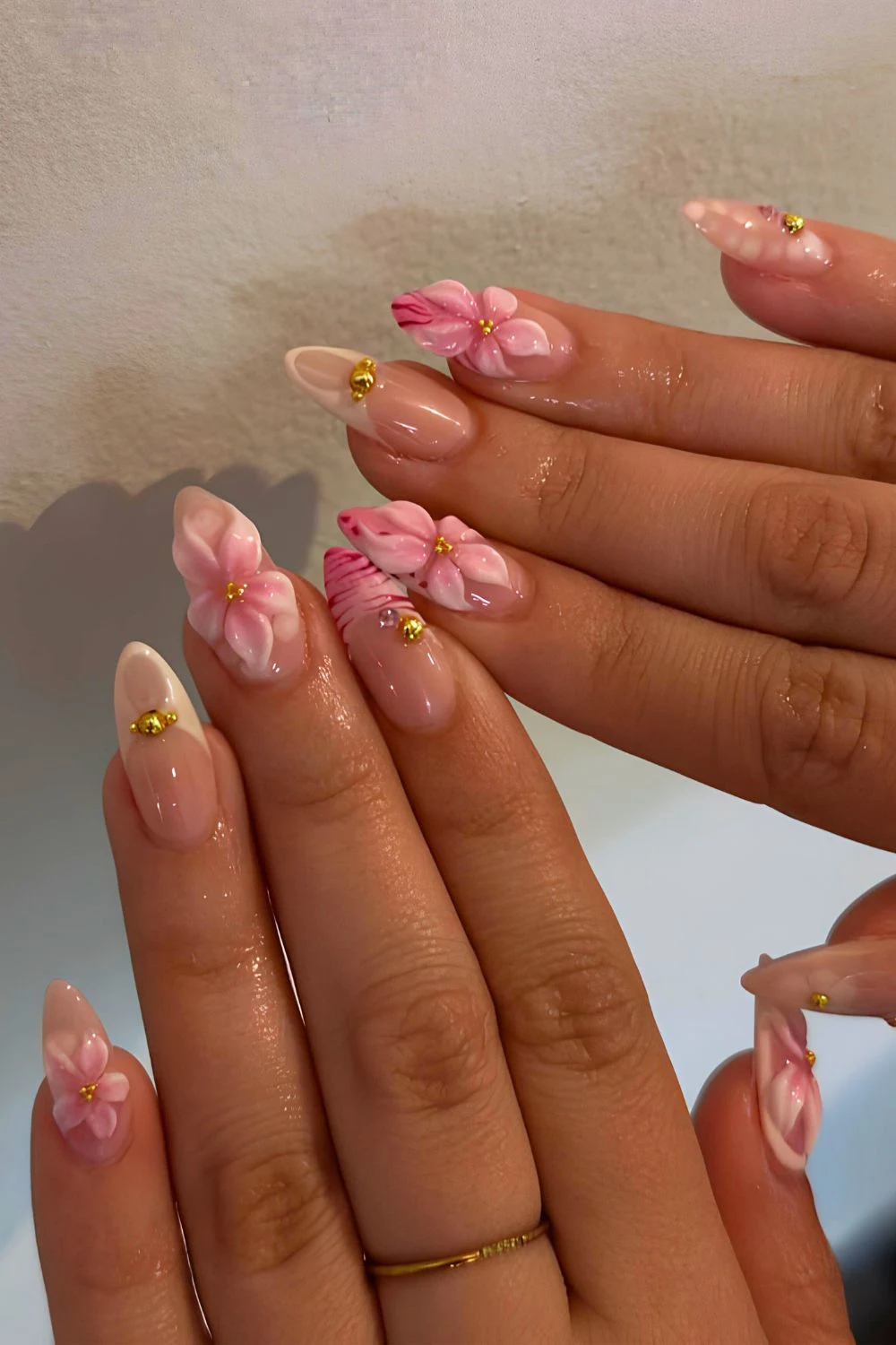 Neutral nails with sculpted pink flowers