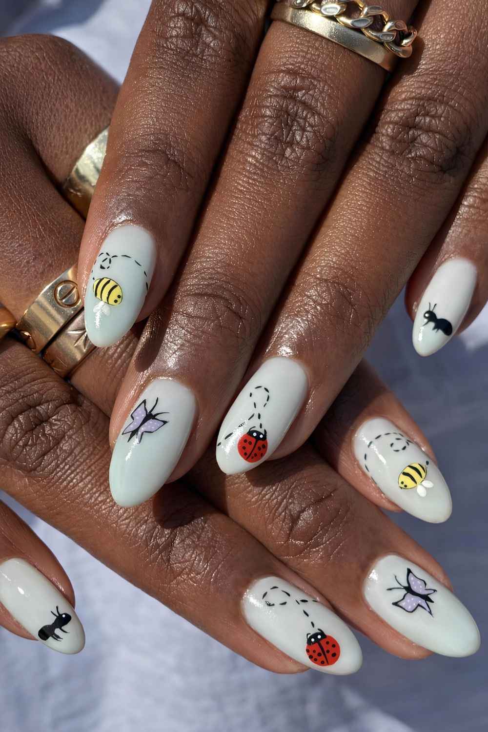 Pale blue mani with bee and ladybug art