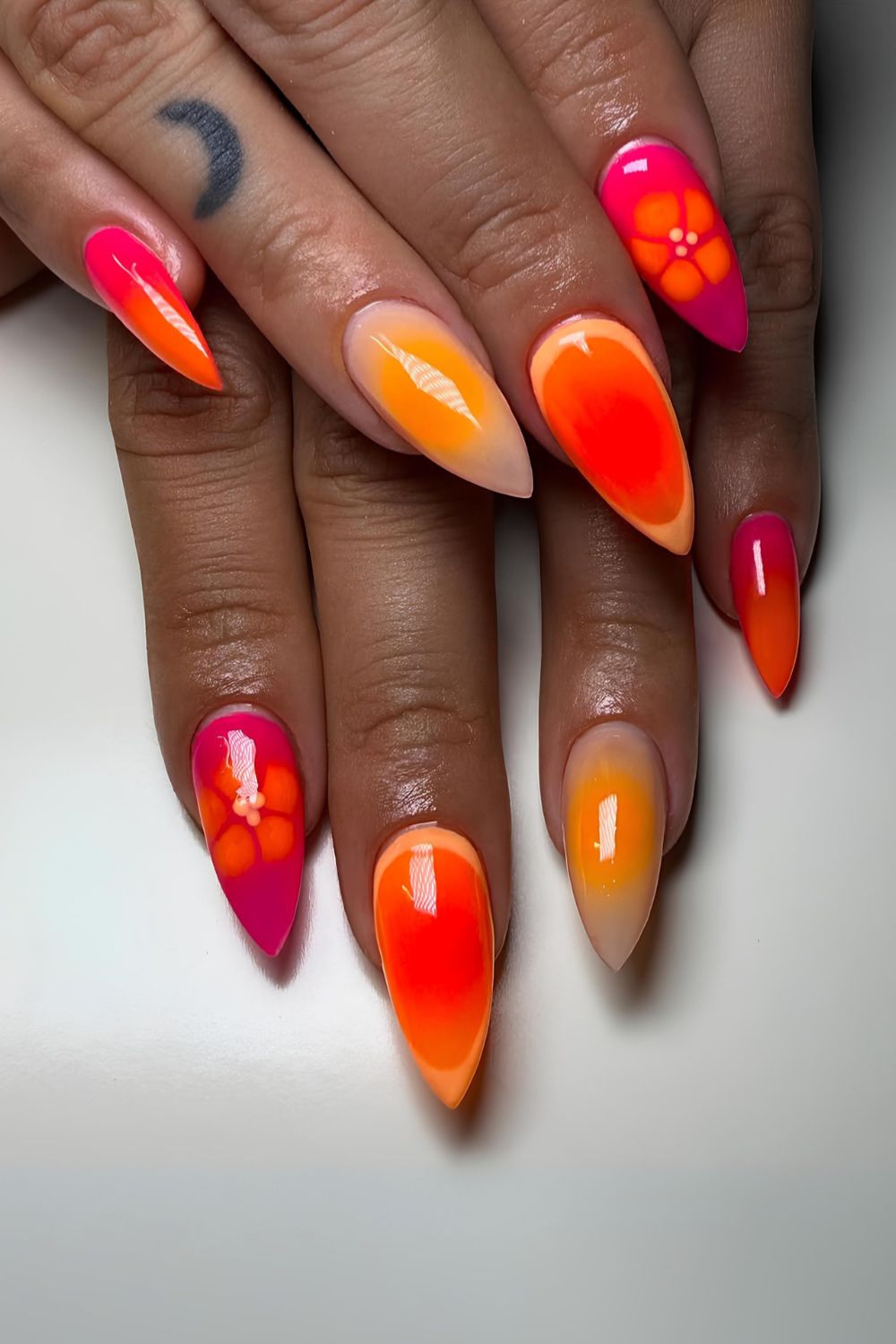 Pink, orange and yellow blended nails with blooming flower accent