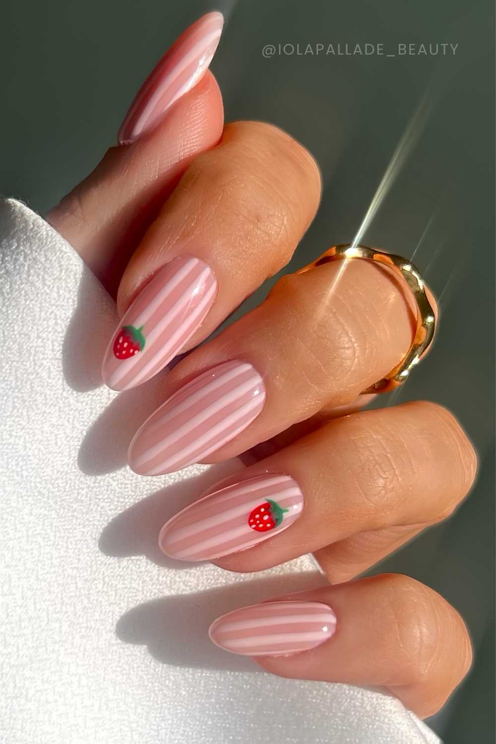 Pink striped nails with strawberry art