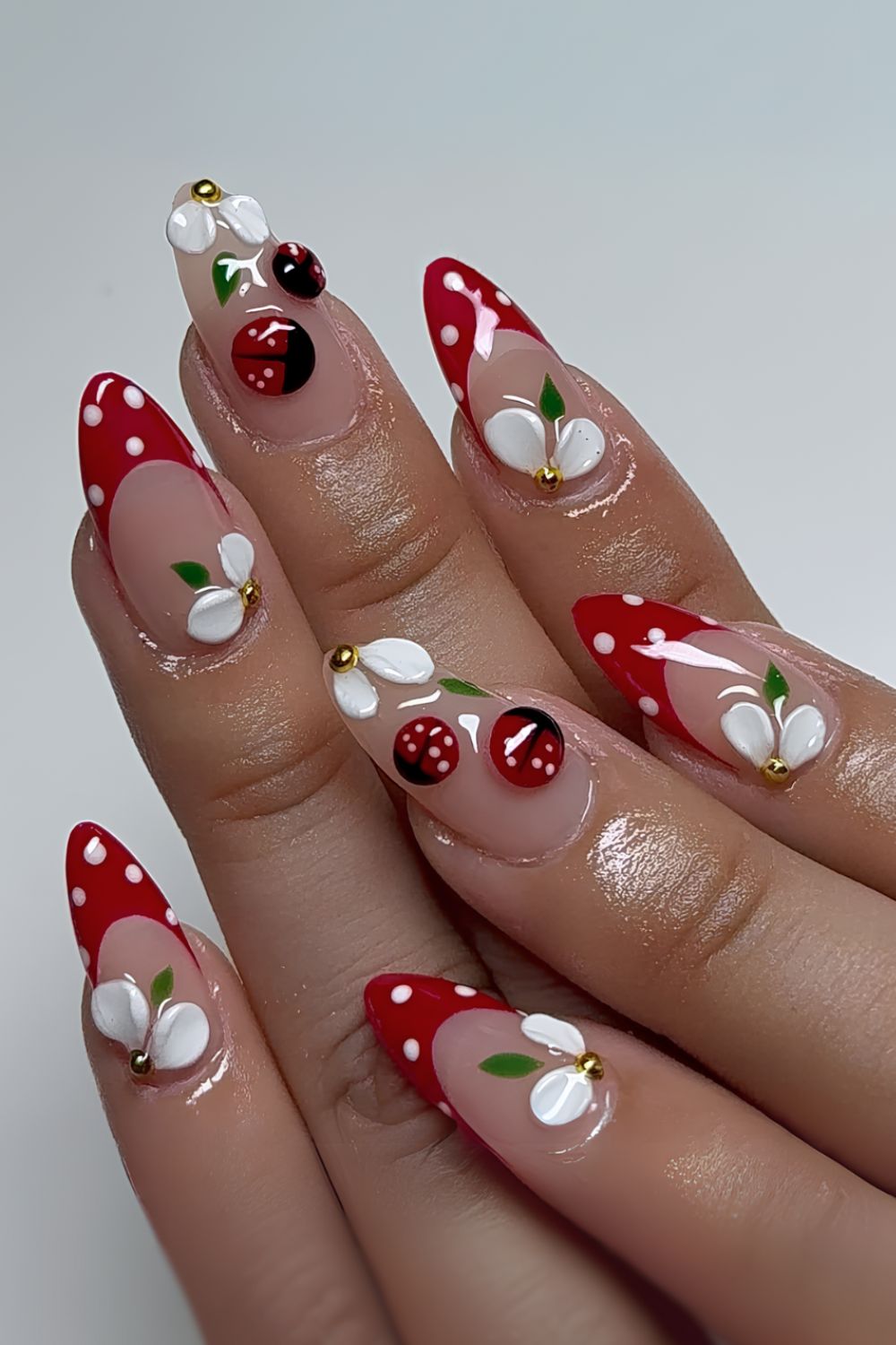 Red and white polka dot nails with sculpted flower and 3d ladybug designs