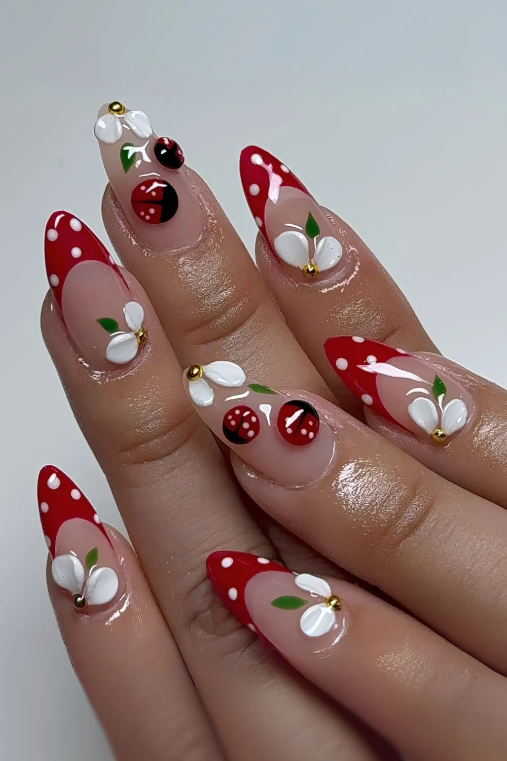 Red and white polka dot nails with sculpted flower and 3d ladybug designs