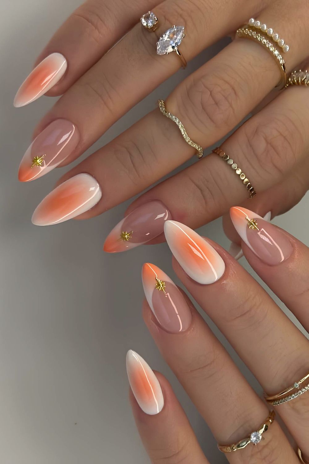 White and orange mani with aura effect and gold stars