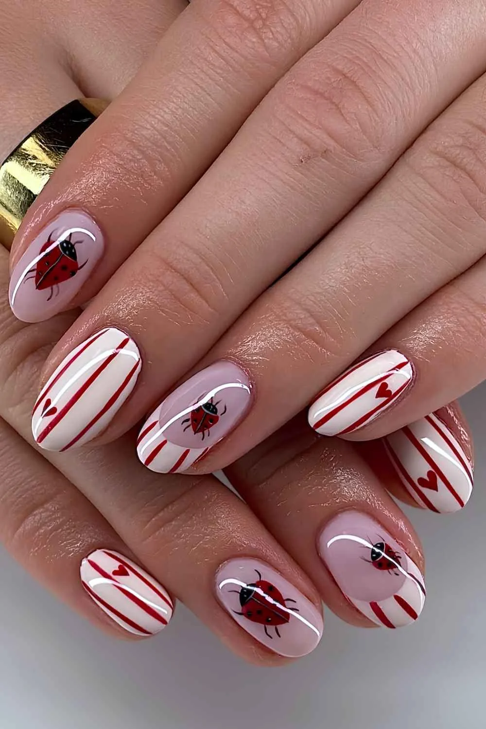 White mani with red stripes and ladybugs