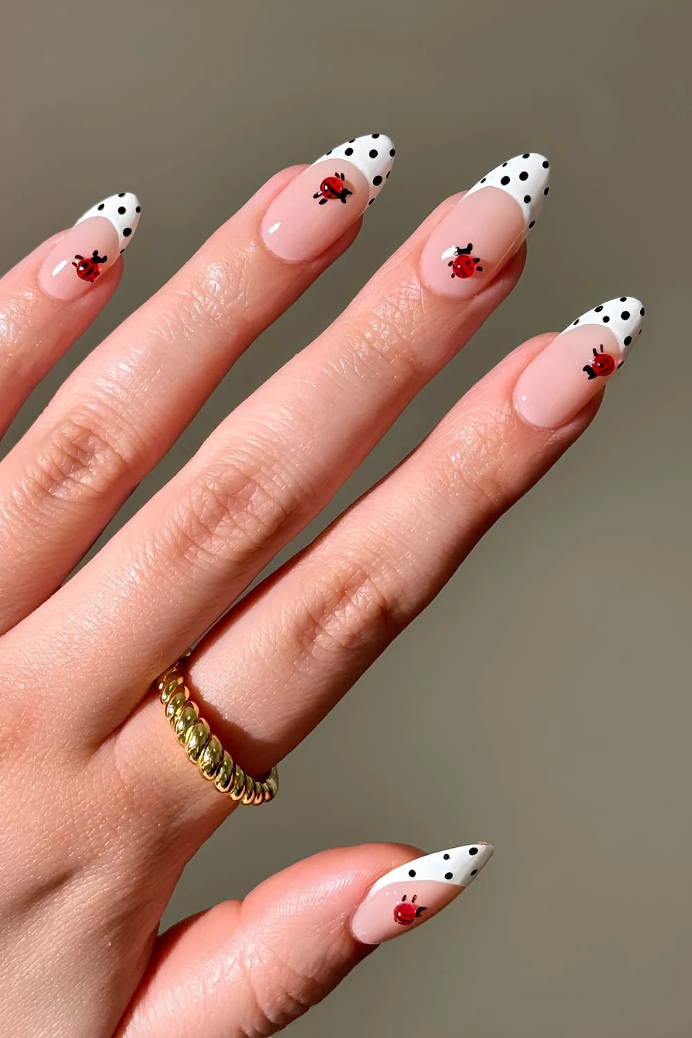 White nails with black polka dots and ladybug nail art