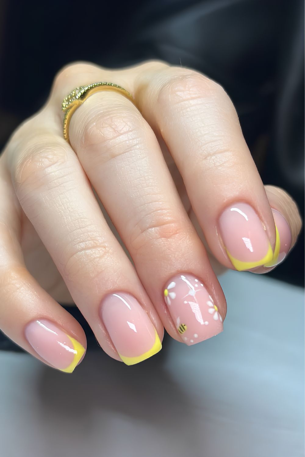 Yellow French tip nails with bees and floral art