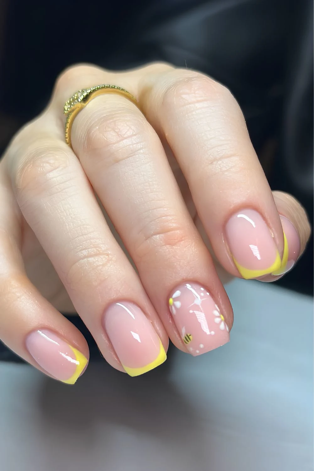 Yellow French tip nails with bees and floral art
