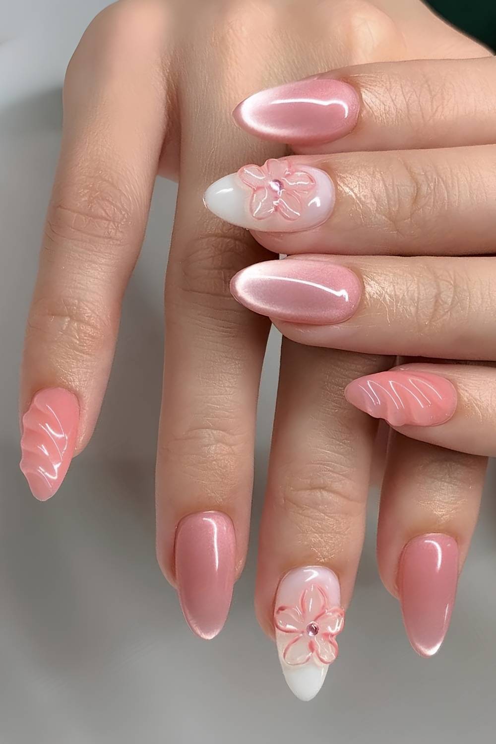 Bright pink cat eye nails with floral accents