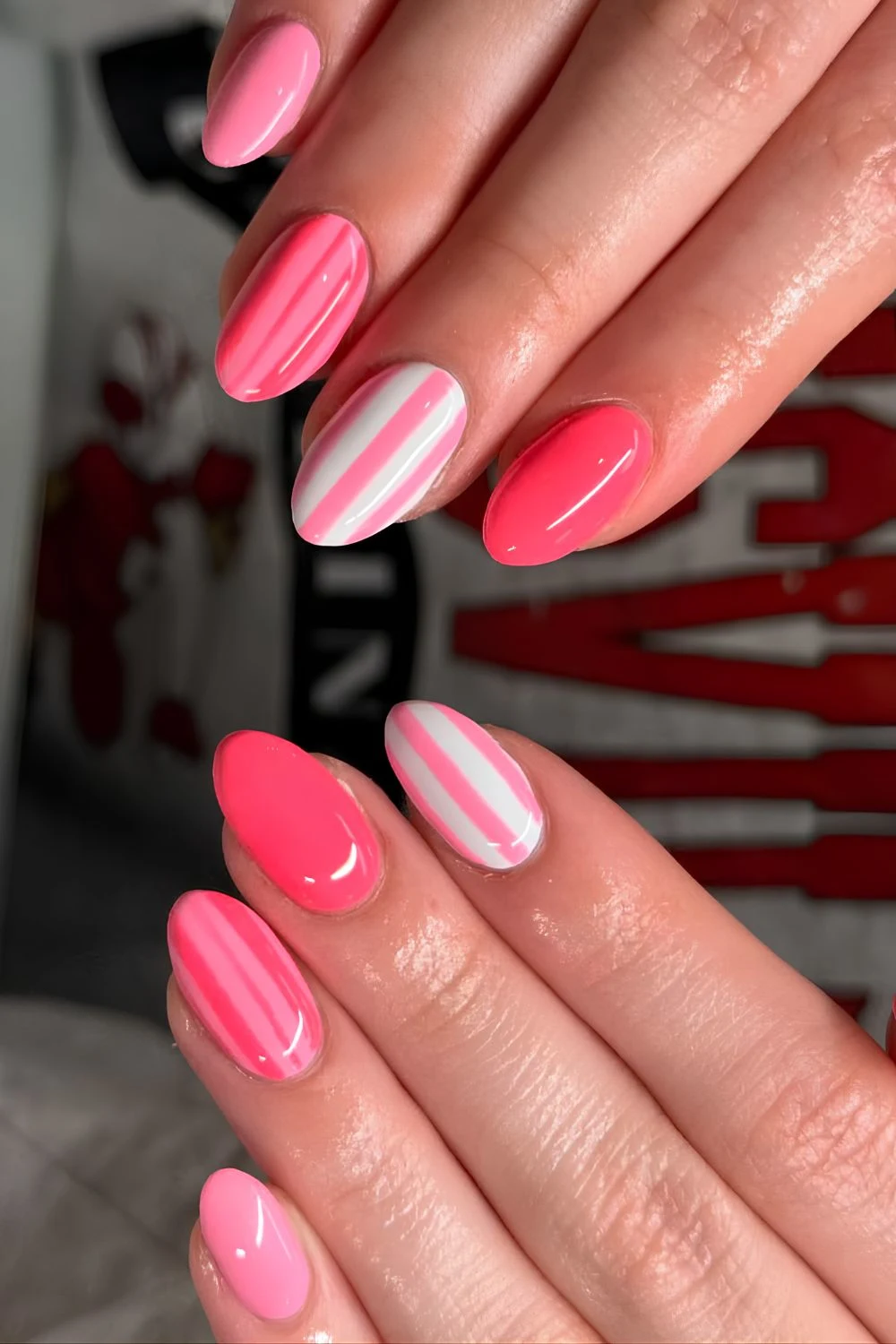 Bright pink skittle nails with stripe accents
