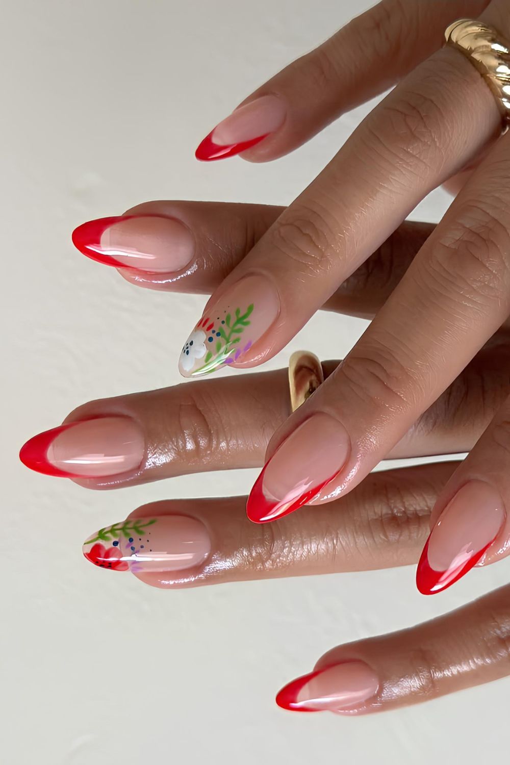 Bright red French tip nails with floral accents