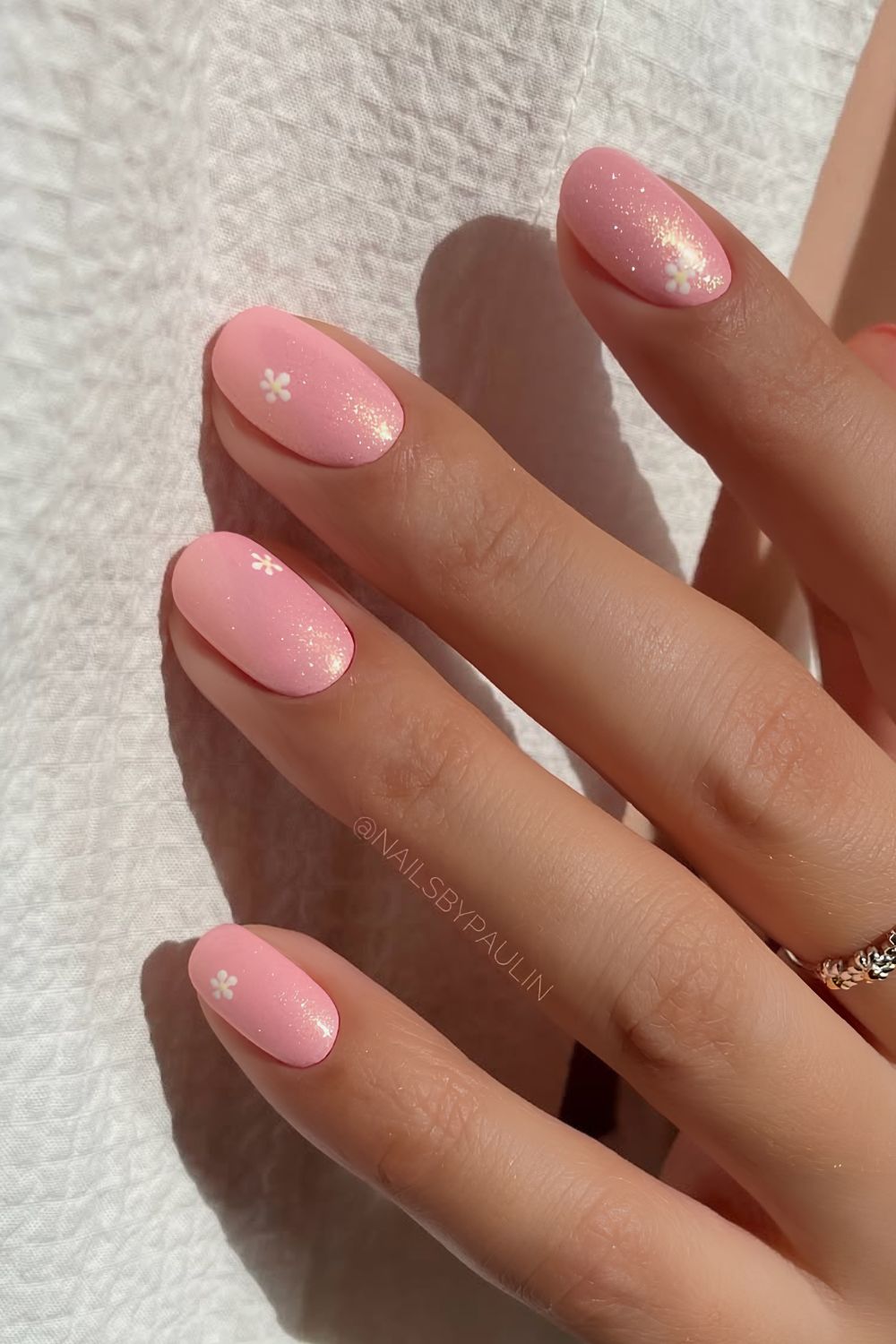 Coral pink shimmery nails with tiny white daisies