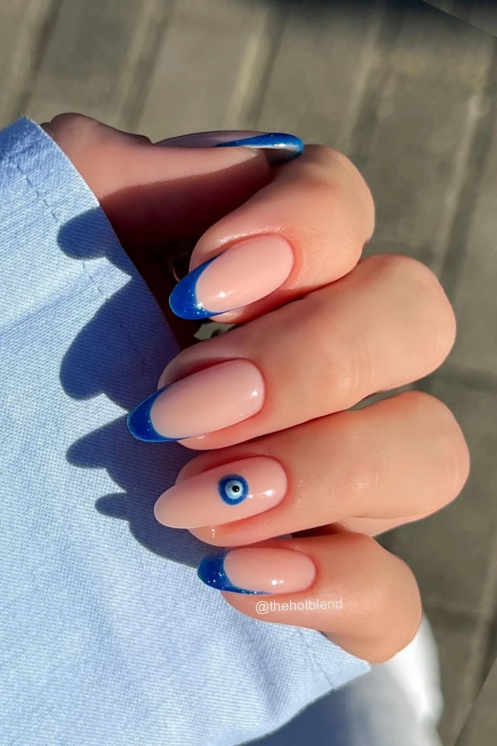 Dark blue glitter French tip nails with evil eye