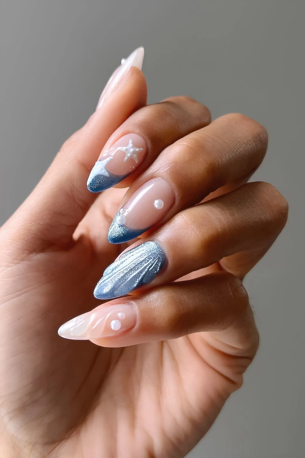 Deeep ocean blue cat eye nails and sheer white textured nails with pearl and white starfish accents
