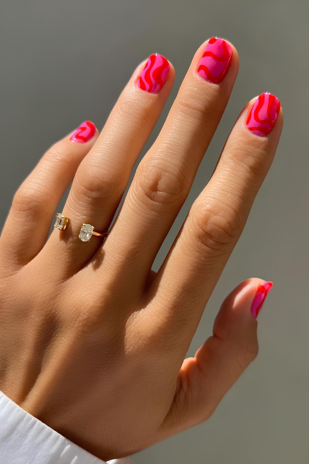 Hot pink nails with red swirls