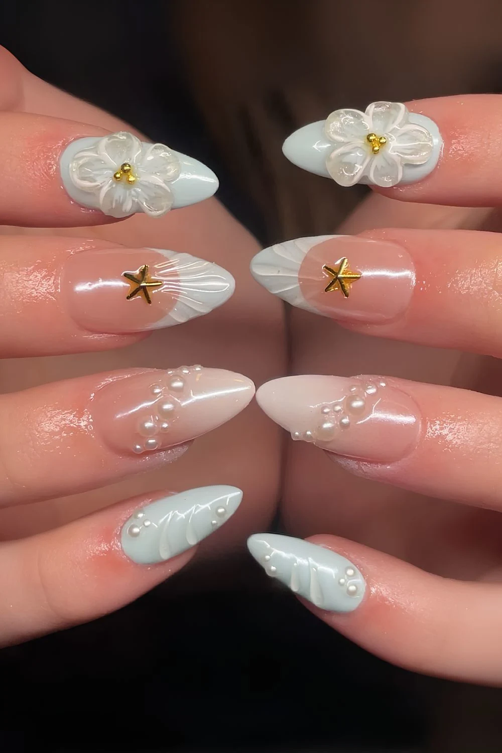 Light blue and white ombre nails with sculpted flowers, pearls and starfish details