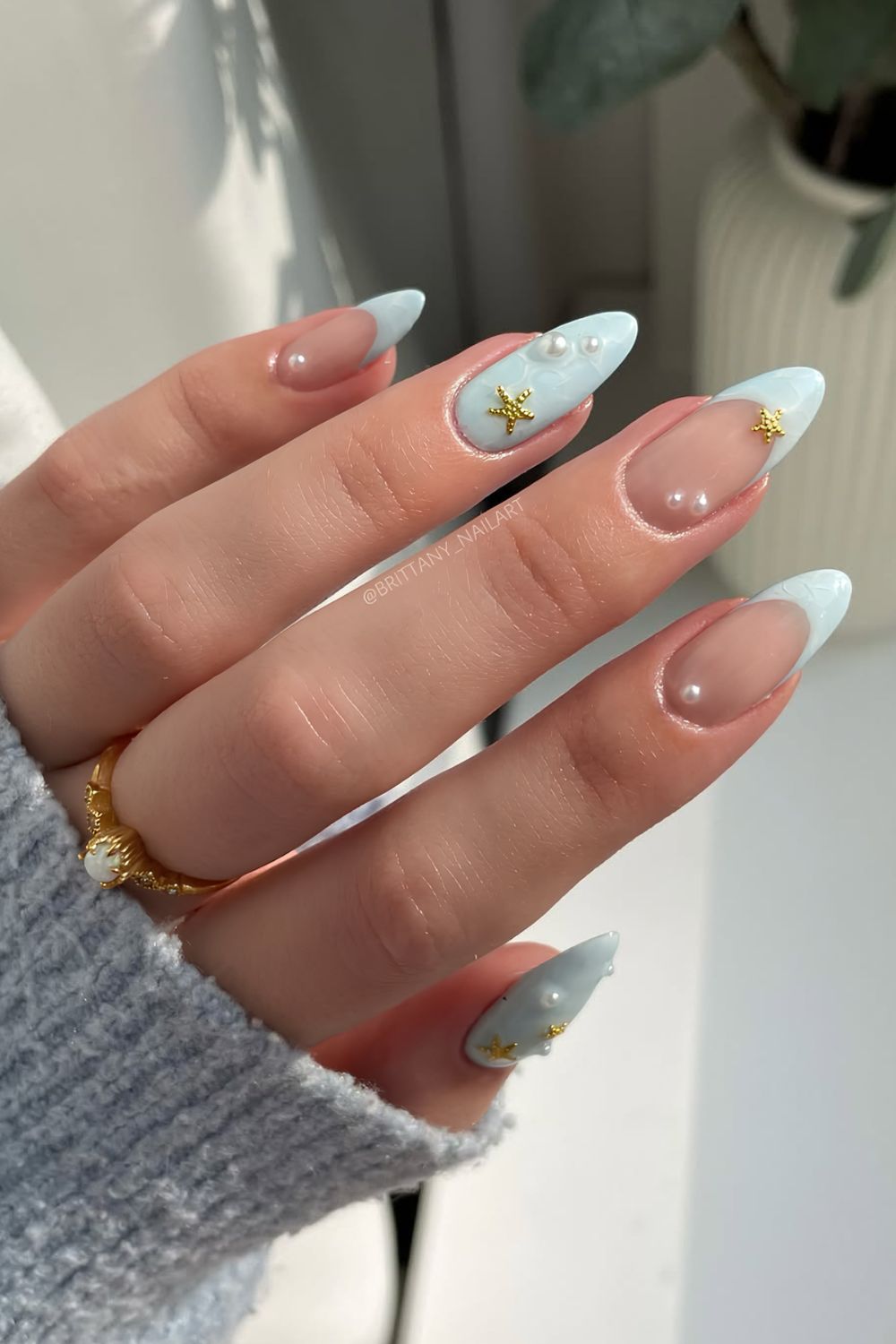 Light blue nails with pearl and starfish nail charms